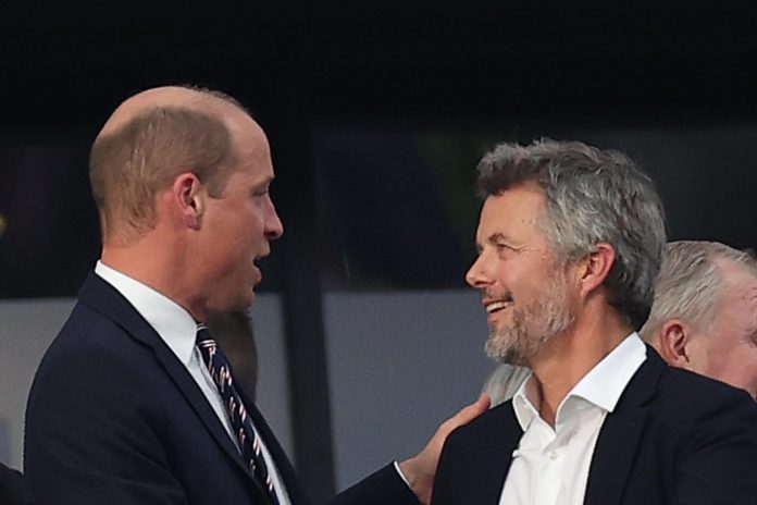 König Frederik (r.) und Prinz William begrüßen sich auf der Tribüne im Frankfurter Stadion. / Source: Crystal Pix/MB Media/Getty Images