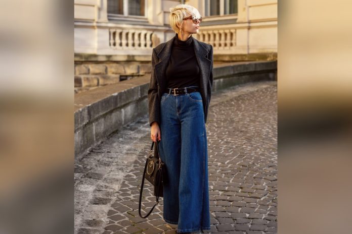 Genau richtig: Dunkelblaue Wide-Leg-Jeans sind im Trend. Dazu passen ein enges Oberteil und ein Taillengürtel perfekt. / Source: Victoria Fox/Shutterstock.com